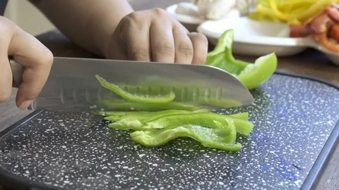 Cook hands cut pepper on a black board on a table with a large cook knife Stock Footage 122148159
