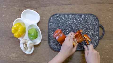 Cook hands cut pepper on a black board on a table with a large cook knife Stock Footage 122200470