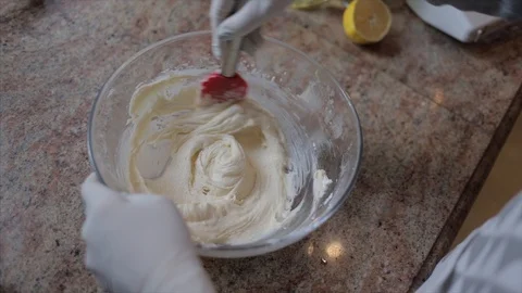 Cook hands in white rubber gloves mixing cream with batter 스톡 동영상 107824326