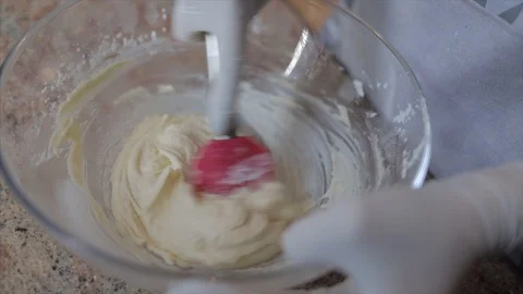 Cook hands in white rubber gloves mixing butter with sugar Stock Footage 107824347