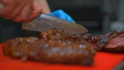Cook of a high-level restaurant cuts steak into slices for a full-course dinner Stock-Footage 218860371