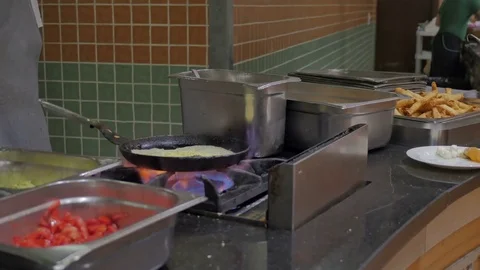 A cook in the hotel restaurant fry an omelet with ingredients from vegetables Stock Footage