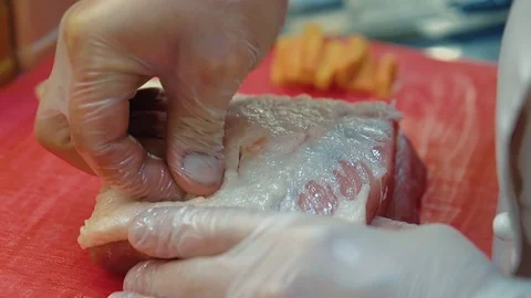 Cook inserts pieces of garlic and carrots into a piece of meat. Stock Footage 104936322