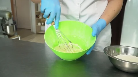 The cook interferes with the dough in the plate, close-up. Slow motion. Stock Footage 85664675