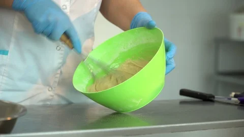 The cook interferes with the dough in the plate, close-up Stock Footage 85664865