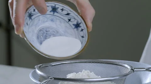 A cook in the kitchen adds ingredients to the flour to make pancakes. Stock Footage 263346576
