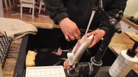 A cook in the kitchen cleaning and cutting fish Stock-Footage 274466326