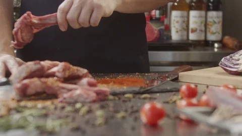 Cook in the kitchen cooks beef ribs with spices. Slow motion video Stock Footage 123898896