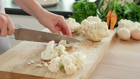 A cook in the kitchen cuts cauliflower into small pieces Stock Footage 262782193