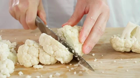 A cook in the kitchen cuts cauliflower into small pieces Stock Footage 262782305