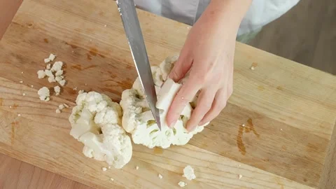 A cook in the kitchen cuts cauliflower into small pieces Stock Footage 262782322