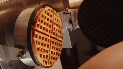 The cook in the kitchen opens a waffle iron with ready-made golden baked Stock Footage 169056453