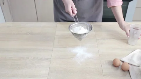 Cook in kitchen pours wheat flour into metal strainer and sift 스톡 동영상 140467162