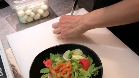 The cook in the kitchen is preparing a salad of tomatoes and herbs. Healthy food Video stock 171592398