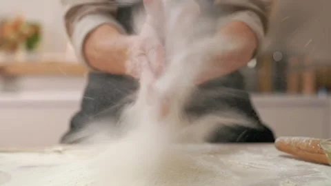A cook in the kitchen sifts flour through a sieve. Kneading raw dough with male  Stock Footage 273501504