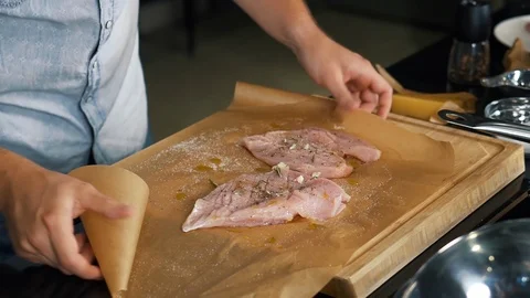 Cook in kitchen in slow motion mixes meat with spices in parchment for baking Stock Footage 122903400