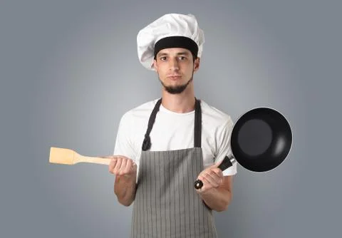 Cook with kitchen tools and empty wallpaper Stock Photos