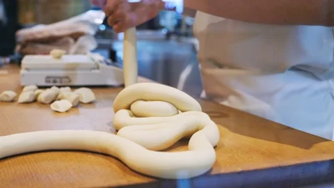 The cook in the kitchen is working with the dough for making dumplings, weighing Stock Footage 226188191