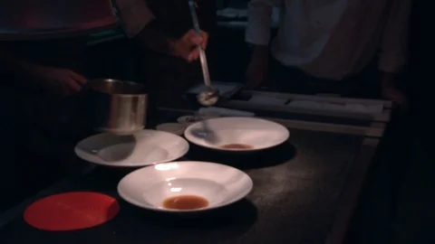 Cook  little pan while adding sauce in plate on restaurant kitchen Stock Footage 114610326