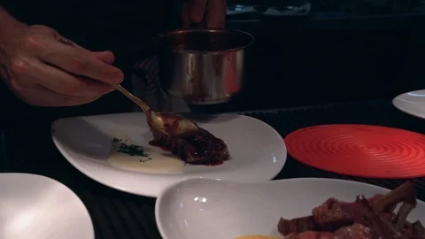 Cook  little pan while adding sauce in plate on restaurant kitchen Stock Footage 114610341