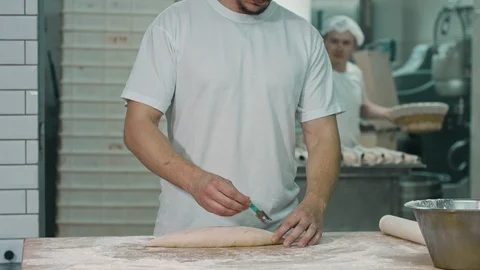 The cook make cuts by the help of blade on the dough. Stock Footage 92580827