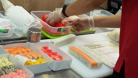 Cook make sushi rolls. Man roll in batter and breadcrumbs tasty rolls in kitchen Stock Footage 119979164