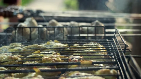 Cook makes barbecued chicken on grill. Meat in yellow marinade on grill in Stock Footage 198922706