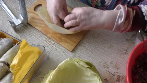 The cook makes cabbage rolls from cabbage and meat Stock Footage 148947525