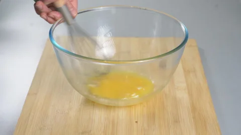 The cook makes dough with their eggs and flour. Whisk the egg yolk and white Stock Footage 232412859