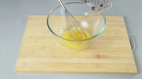 The cook makes dough from their eggs and flour. Adds sunflower oil. Gray Stock Footage 232414372