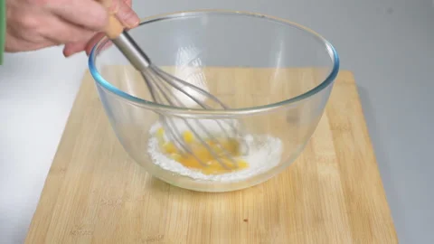 The cook makes dough with their eggs and flour. Whisk the egg yolk and white Stock Footage 232414618