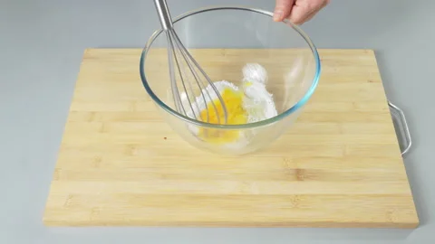 The cook makes dough with their eggs and flour. Whisk the egg yolk and white Stock Footage 232414882