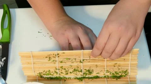 Cook makes a green sushi roll Stock Footage 88492873