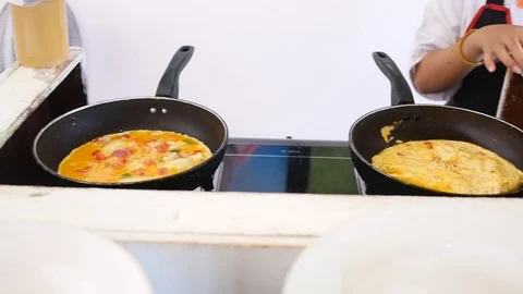 Cook makes an omelette of eggs in two pans. HD, 1920x1080, slow motion Video stock 96121628