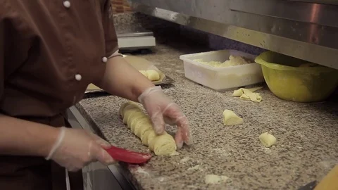 Cook makes roll of dough with curd filling, cuts into flat pieces Stock Footage 76884952