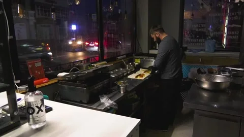 A cook makes shawarma in a dark cafe in a big city during a blackout Stock Footage 231576609
