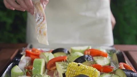 The cook makes vegetable ragout with codfish pieces of zucchini and aubergine Stock Footage 77589615