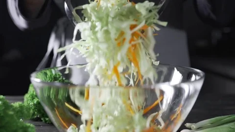The cook makes vegetable salad with cabbage and carrot, vegetarian meal, fresh Stock Footage 76937318