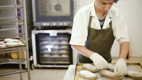 Cook making cuts on the bread before baking 動画素材 69779018
