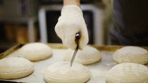 Cook making cuts on the bread before baking Stock Footage 69779225