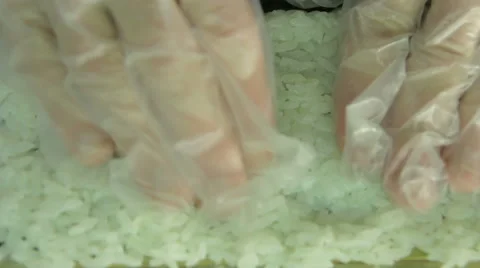 Cook making sushi rolls, spreading rice over nori, upside view Stock Footage 41952339