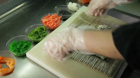 Cook making sushi rolls, spreading rice over nori Stock Footage 41953853