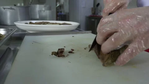 Cook man cuts cooked meat on a cutting table Stock Footage 88898512