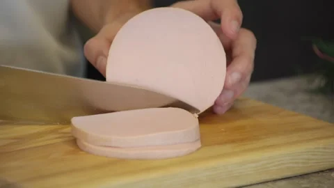Cook Man Cutting Boiled Sausage on Wooden Board Stock Footage 252109232