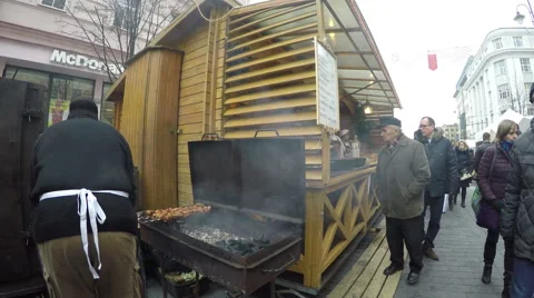 Cook man sack coal into roaster and bake fresh meat in festival Stock Footage 53001175
