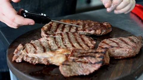 The cook measures the temperature in steaks Stock Footage 125889861