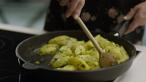 The cook mixes fried potatoes with herbs in a frying pan Stock Footage 264033346