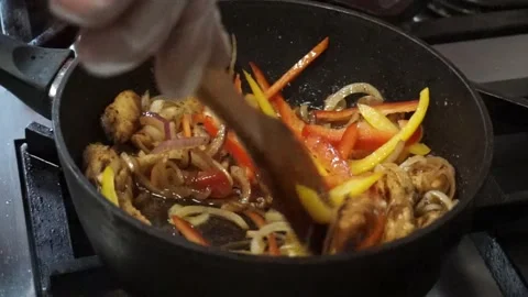 The cook mixes the meat and vegetables in a frying pan Video stock 155441053