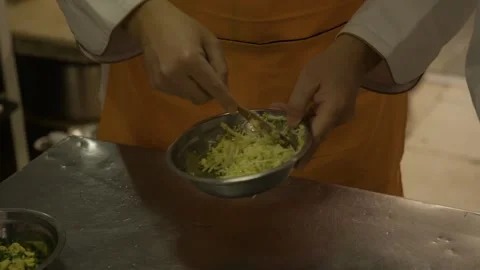 Cook Mixing Shredded Vegetable Filling in Metal Bowl at Kitchen Workstation Stock Footage 345879751