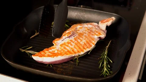 Cook moving a chicken breast while grilling Stock Footage 105113678